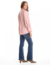 Camisa de color rosado con cuello clásico y cierre frontal de botones. Presenta mangas largas con detalles calados y puños anchos abotonados.