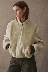 Campera tipo bomber de textura afelpada en color negro, con cierre frontal, cuello alto y puños y ruedo elásticos en cuero.