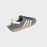 Championes Adidas Handball Spezial de ante gris con las emblemáticas tres tiras blancas en los laterales, talón blanco y suela de goma color caramelo.