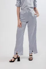 Pantalón negro de seda con tiro alto, corte recto, pinzas en la pretina y tajos en el ruedo.