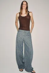 Jeans de tiro medio con corte barrel, confeccionados en denim con estampado floral integral. Presentan diseño de cinco bolsillos, cintura con trabillas y cierre frontal con cremallera y botón.