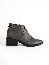 Bota corta de cuero vacuno texturizado en color gris oscuro, con diseño de solapa lateral y costuras a la vista. Posee taco cuadrado de 5 cm y suela de caucho antideslizante.