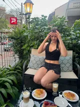 Top corto negro con escote drapeado y espalda descubierta.