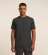 Remera deportiva masculina de manga corta con cuello redondo, confeccionada en tejido técnico con tecnología Dry para mayor transpirabilidad. Presenta detalles reflectantes en los hombros y un diseño liso en color verde melange.