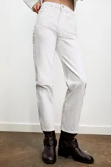 Jeans de mujer, tiro alto, color azul medio con efecto desgastado (lavado claro en muslos y oscuro en bordes). Corte recto y ancho (mom fit) con cinco bolsillos y cierre frontal de botón y cremallera.