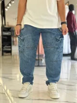 Pantalón cargo de jean azul con múltiples bolsillos en los laterales y diseño holgado.