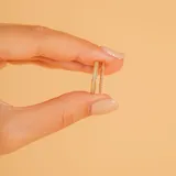 Anillo doble de oro amarillo 18k, compuesto por una banda fina con engaste de pequeños brillantes y otra banda lisa con un brillante central solitario.