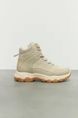 Zapatilla tipo bota de estilo hiking, confeccionada en combinación de cuero sintético y nylon, con suela de goma dentada y cordones al tono.