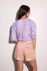 Short de lino color amarillo con estampado floral en tonos rosados y blancos.