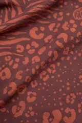 Musculosa marrón con estampado animal print, de tejido aireado y lazos laterales para un calce regulable.