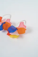 Aros colgantes con diseño de flor en color negro, con gancho metálico dorado.