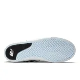 Championes urbanos New Balance modelo 306, con capellada de gamuza gris, detalles en negro y celeste, logo "N" característico en los laterales y suela blanca de goma vulcanizada.