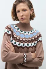 Polera de tejido de punto en color tostado, con diseño de estampado geométrico tipo nórdico en la zona del cuello, hombros y puños. Presenta cuello alto acanalado y mangas largas.