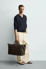Bolso shopper de hombro fabricado en piel con acabado abatanado. Cuenta con compartimento principal con cierre de cremallera, interior con bolsillo plano y bolsillo con cierre. Incluye dos asas de mano, asa de hombro y detalle de llavero colgante.