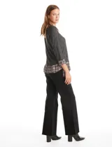 Buzo de tejido fino color beige con diseño de doble capa que simula una camisa debajo. Presenta cuello redondo, mangas largas con puños de gasa estampada en animal print, y ruedo con volado de la misma tela. Incluye detalles de frunces en los laterales.