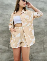 Camisa de corte oversize con estampado botánico en tonos beige y blanco, cuello clásico, cierre frontal con botones y bolsillo en el pecho.