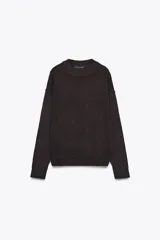 Jersey de punto de cuello redondo y manga larga con hombro caído y costuras marcadas. Presenta acabados en rib en cuello, puños y bajo.