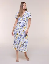 Vestido midi de seda fría blanca con estampado floral en tonos azules y amarillos, escote en V con cuello solapa, mangas cortas, lazo ajustable en la cintura y falda plisada.