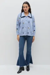 Saco de punto color bordó con bordados artesanales de flores en tonos rosados. Presenta un cuello con detalle de volados en color crema y cierre frontal con botones. De silueta amplia y cómoda.