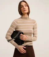 Suéter de punto color beige con rayas horizontales blancas, cuello alto y mangas largas con abertura para el pulgar.