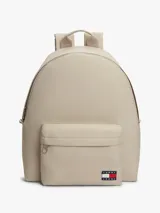 Mochila Tommy Jeans Essential Dome de tejido ripstop en color beige, con diseño curvo, compartimento principal con cierre de cremallera, bolsillo exterior frontal con cremallera, asa superior y correas ajustables y acolchadas. Incluye parche con el logo de la marca en el bolsillo frontal.