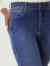 Pantalón de jean corte skinny, de tiro medio y color azul oscuro con costuras en contraste.