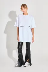 Remerón de corte oversized confeccionado en algodón, con cuello redondo y mangas cortas. Presenta estampados gráficos en color negro en la parte frontal.