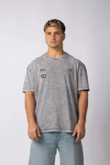 Remera de algodón con efecto lavado ácido en color gris, de corte holgado y manga corta. Presenta estampados gráficos minimalistas en el pecho y cuello redondo acanalado.