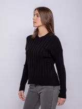 Sweater de punto color beige, con cuello redondo y diseño acanalado con pequeños calados.