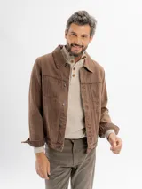 Campera de jean sobreteñida en color marrón, con corte regular fit, cuello clásico y cierre frontal mediante botones metálicos. Presenta bolsillos frontales con solapa y bolsillos laterales.