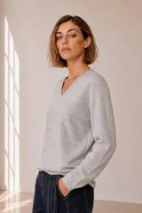 Sweater de punto color gris melange, con escote en V y mangas largas de corte recto.