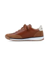 Championes urbanos color camel, confeccionados en una combinación de cuero perforado y gamuza. Presentan detalles en blanco en los laterales, cordones al tono y suela de goma dentada con entresuela blanca.