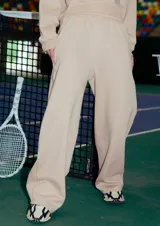 Pantalón de jogging recto color camel, confeccionado en frisa. Tiene bolsillos laterales, cintura elastizada y puño estampado en la botamanga trasera con el isologo de Renée.