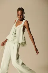 Blusa color verde menta de tejido suave y vaporoso, con volados en el escote y diseño abierto en los laterales.