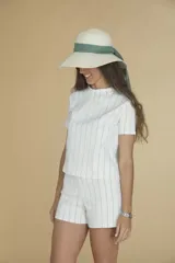 Sombrero de paja color marfil con ala ancha y cinta verde.