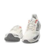 Championes de trail running New Balance Nitrel, color beige y gris, con detalles en naranja y suela dentada.