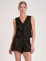 Chaleco negro de corte ajustado, con escote en V y cierre frontal de botones oscuros. Presenta un diseño de chaleco de traje con solapas falsas y un bajo ligeramente peplum o con vuelo.