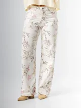 Pantalón wide leg de denim rígido con estampado floral chintz en tonos amarillo y rosa pastel sobre base blanca.