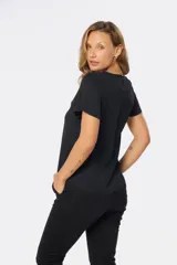 Blusa blanca con estampado floral negro, de corte recto y manga corta.