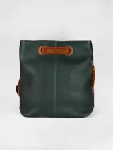 Mochila de cuero graneado color verde oscuro, con detalles en cuero color suela. Cuenta con manija superior, cierre lateral y costuras decorativas verticales.