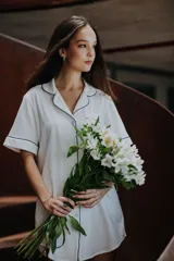 Camisa blanca de algodón con cuello tipo pijama y mangas cortas. Presenta ribete azul marino en cuello, mangas y botonera. Corte holgado y largo arriba de la rodilla.