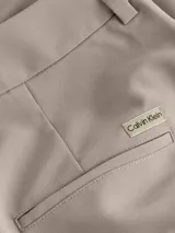 Pantalón de vestir color gris topo, de corte sastre y pierna ancha, con pinzas en la cintura y bolsillos laterales.