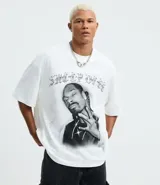 Remera blanca de algodón con cuello redondo, mangas cortas y corte oversized. Presenta un estampado frontal en blanco y negro del rapero Snoop Dogg, con letras góticas en la parte superior.