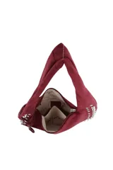 Cartera tipo hobo de gamuza color bordó, con diseño de media luna, decorada con tachas metálicas plateadas en los bordes y un dije colgante en forma de corazón con tachas. Cuenta con cierre superior y logo de la marca grabado en el frente.