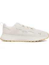 Championes urbanos Under Armour modelo Street Mirage, color beige con detalles en blanco. Presentan una parte superior de malla transpirable con superposiciones de gamuza, entresuela de EVA acolchada y suela de goma con agarre.