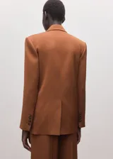 Blazer cruzado marrón con solapas de muesca, bolsillos con solapa y cierre frontal de botones.