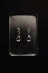 Caravanas colgantes de plata 950 con diseño de textura orgánica e irregular en la parte superior y piedra facetada ovalada de praisiolita (cuarzo verde) colgante. Cierre de perno y tope.