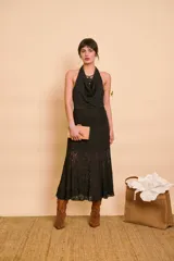 Pollera midi de encaje negro, con diseño semitransparente y corte acampanado.