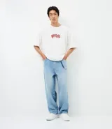 Pantalón de jean modelo skater, de corte holgado y tiro medio, con diseño de cinco bolsillos y detalle de cordón decorativo en la cintura.