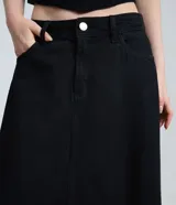 Falda larga de denim color negro, corte evasé con cintura media, bolsillos funcionales, recortes frontales con costura central y bajo desflecado.